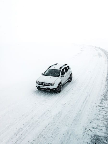 Picture of a white Dacia Duster on a snowy road